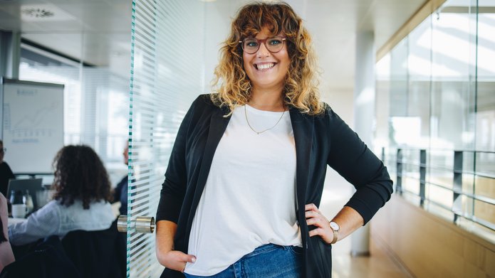 uśmiechnięta kobieta w okularach z kręconymi włosami